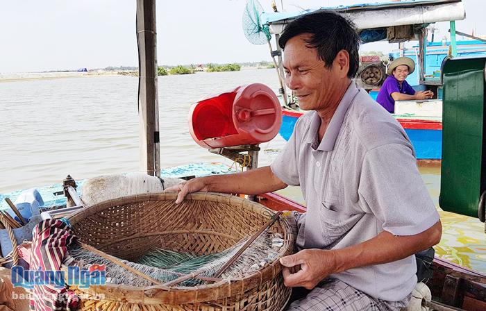 Ngư dân Nguyễn Chanh, phường Phổ Vinh (thị xã Đức Phổ) mang thúng đựng dây câu xuống tàu để chuẩn bị cho hành trình vươn khơi lúc nửa đêm.
