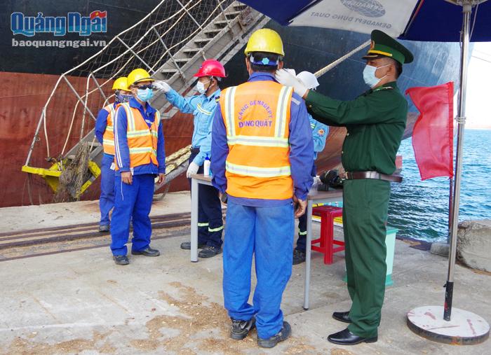 Quân y Đồn Biên phòng cửa khẩu cảng Dung Quất kiểm tra thân nhiệt người lao động làm việc trên tàu nước ngoài.
