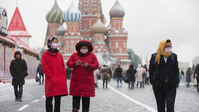 Khách du lịch đeo khẩu trang bên ngoài Điện Kremlin ở Moscow. (Ảnh: Bloomberg)
