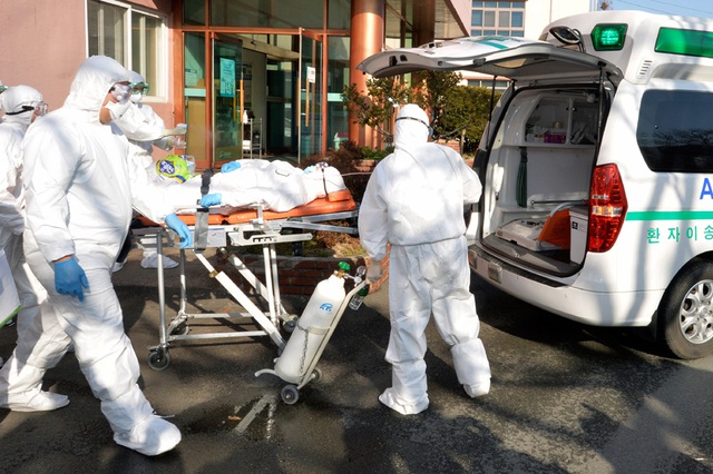 Nhân viên y tế chuyển một bệnh nhân nghi nhiễm Covid-19 tới bệnh viện ở Cheongdo, Hàn Quốc. (Ảnh: News18)