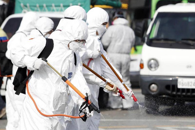 Nhân viên mặc đồ bảo hộ phun khử trùng tại Gwangju, Hàn Quốc. (Ảnh: AP)