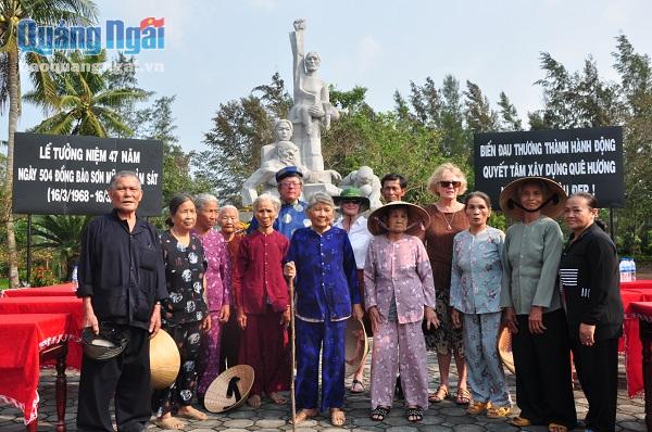 Những nhân chứng của vụ thảm sát Sơn Mỹ và du khách nước ngoài cùng chụp ảnh lưu niệm trước tượng đài Sơn Mỹ
