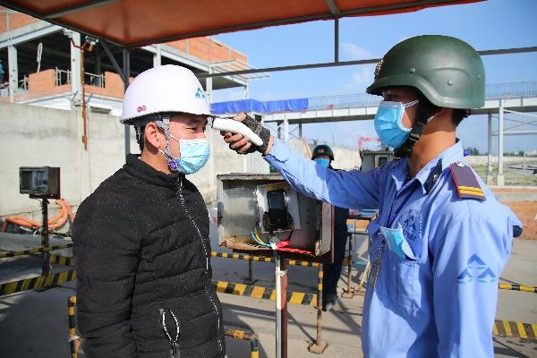 Bảo vệ thực hiện đo thân nhiệt tại KLH Hòa Phát Dung Quất. Nguồn:  HPG News