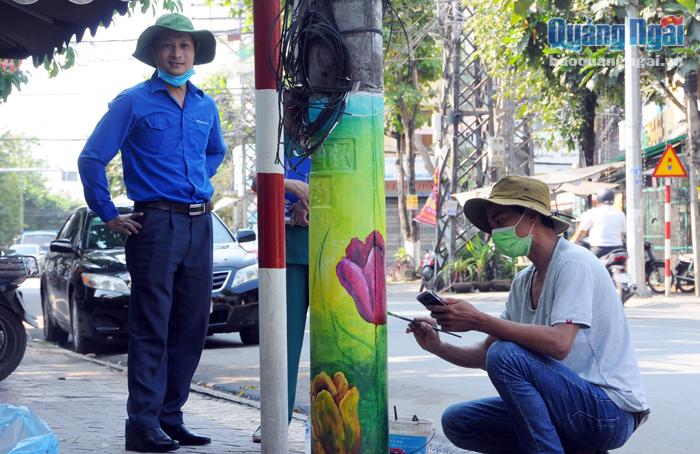Đoàn viên thanh niên phường Chánh Lộ (TP.Quảng Ngãi) đang trang trí cho các cột điện dọc tuyến đường Phan Đình Phùng. 