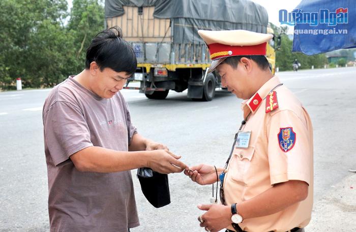 Lực lượng Cảnh sát giao thông kiểm tra giấy tờ các phương tiện tham gia giao thông trên Quốc lộ 1.