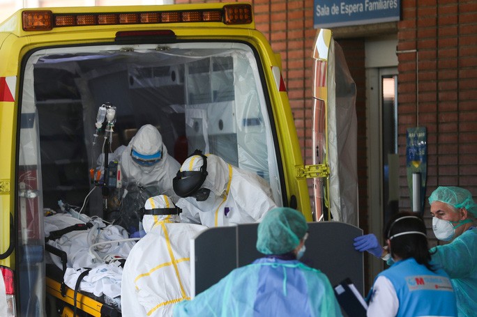 Nhân viên y tế đưa bệnh nhân nhiễm Covid-19 đến một bệnh viện ở TP Leganes - Tây Ban Nha hôm 26-3. Ảnh: Reuters