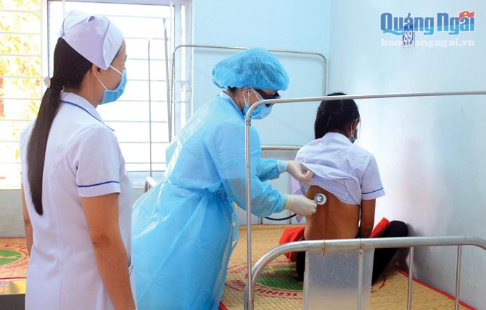 Cán bộ y tế làm công tác phòng, chống lây nhiễm ở Trung tâm Y tế huyện Bình Sơn khám sức khỏe cho bệnh nhân.