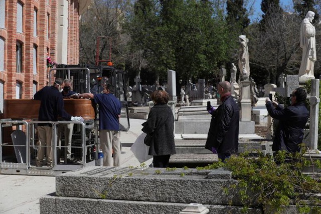 Nhân viên nhà tang lễ chuẩn bị chôn cất quan tài người đã khuất ở Tây Ban Nha hôm 4/4 (Ảnh: Reuters)