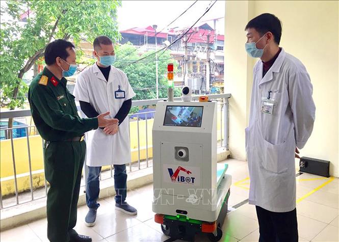 Đại diện Học viện kỹ thuật quân sự giới thiệu robot với các bác sĩ bệnh viện Bắc Thăng Long. Ảnh: TTXVN.