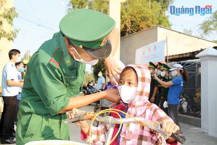 Chiến sĩ Bộ đội Biên phòng tỉnh tặng khẩu trang chống dịch cho trẻ em khu vực biên giới biển.