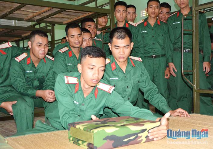 Chiến sĩ trẻ tại Tiểu đoàn huấn luyện chiến sĩ mới hướng dẫn nhau gấp chăn màn ngày mới vào đơn vị. 