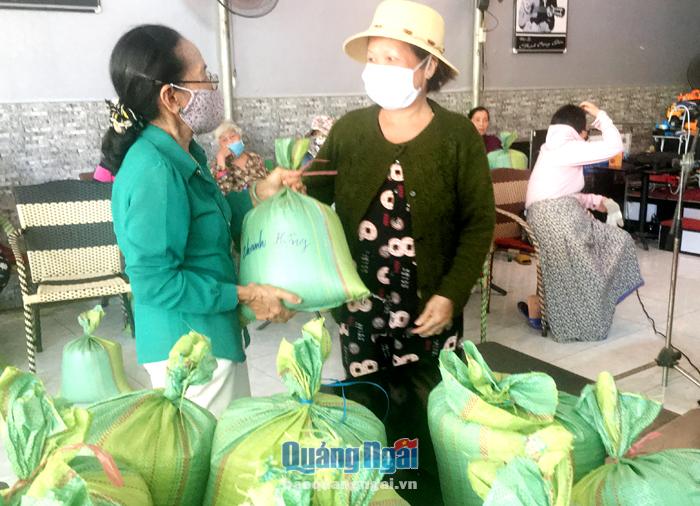 Bà Lê Thị Thanh Hồng (bên trái), ở phường Trần Hưng Đạo (TP.Quảng Ngãi) tặng gạo cho hộ nghèo.