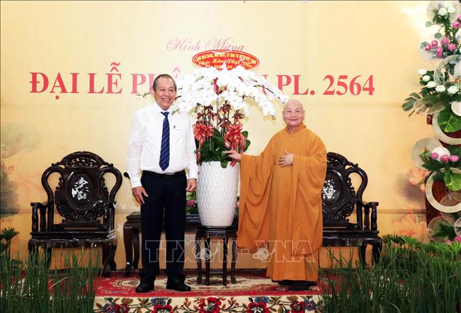 Phó Thủ tướng Thường trực Chính phủ Trương Hòa Bình (trái) tặng hoa chúc mừng Hòa thượng Thích Thiện Nhơn, Chủ tịch Hội đồng Trị sự, Giáo hội Phật giáo Việt Nam (phải) và các tăng ni, phật tử nhân Đại lễ Phật đản.