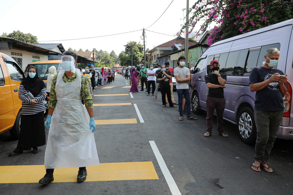 Người dân Malaysia xếp hàng chờ xét nghiệm ở một trung tâm xét nghiệm virus corona - Ảnh: REUTERS