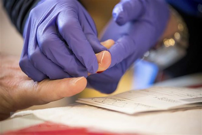 Nhân viên y tế lấy mẫu xét nghiệm Covid-19 tại Brooklyn, New York, Mỹ, ngày 25-4-2020. (Ảnh: THX/TTXVN)
