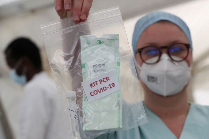 Một nhân viên y tế cầm mẫu xét nghiệm tại một bệnh viện ở Bỉ. Ảnh: Reuters