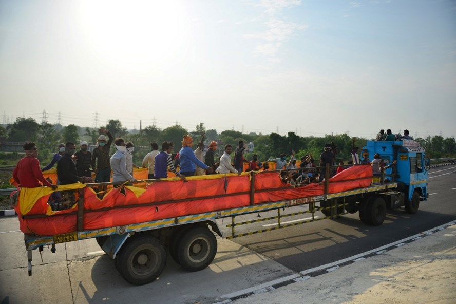 Công nhân Ấn Độ ở ngoại ô Allahabad đi trên một chiếc xe tải trở về quê nhà hôm 12.5 sau khi chính phủ nới lỏng hạn chế chống dịch COVID-19. Ảnh: AFP.