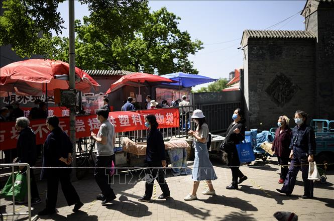 Người dân xếp hàng thực hiện biện pháp giãn cách xã hội khi vào chợ tại Bắc Kinh, Trung Quốc, ngày 10/5/2020. Ảnh: AFP/TTXVN