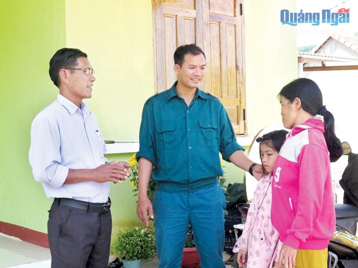 Phó Bí thư Đảng ủy xã Nghĩa Sơn, huyện Tư Nghĩa (bên trái) thăm hỏi hộ nghèo ở khu tái định cư.