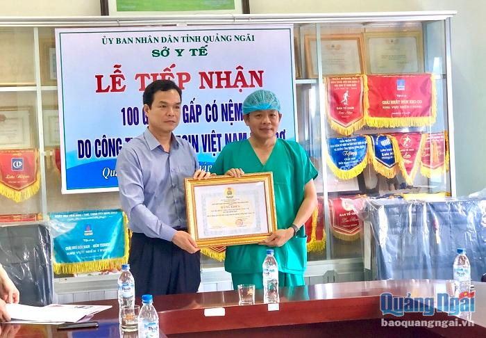 Phó Chủ tịch UBND tỉnh Đặng Ngọc Dũng trao bằng khen của Liên đoàn Lao động tỉnh cho Trung tâm Y tế huyện Bình Sơn vì đã có thành tích trong công tác phòng chống dịch Covid-19