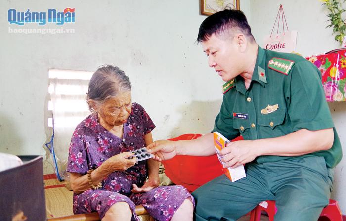 Y sĩ Nguyễn Anh Tuấn, Đồn Biên phòng Bình Hải, thăm khám và phát thuốc cho cụ Nguyễn Thị Diên.