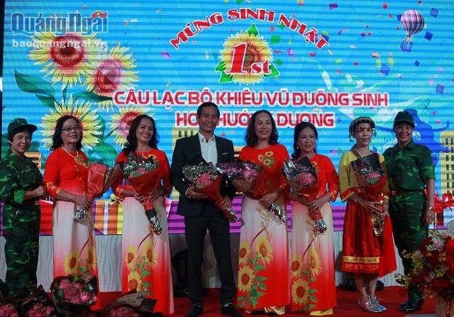 BTC trao hoa cho thành viên Ban Chủ nhiệm CLB Khiêu vũ dưỡng sinh Hoa Hướng Dương.