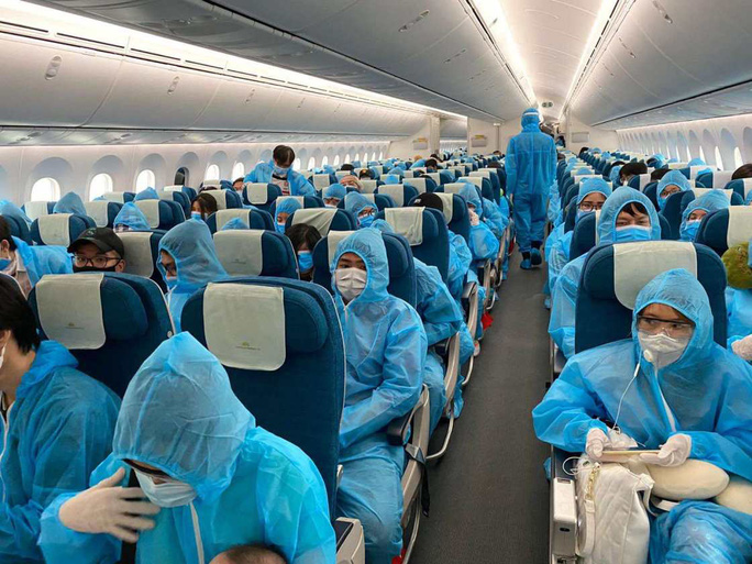 Toàn bộ hành khách trên chuyến bay bảo hộ công dân từ Anh về sân bay Tân Sơn Nhất đều mặc đồ bảo hộ trong suốt chuyến bay - Ảnh: VNA