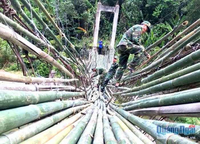Thanh niên lực lượng vũ trang tỉnh sửa chữa cầu treo dân sinh ở thôn Mang He, xã Sơn Bua (Sơn Tây). 