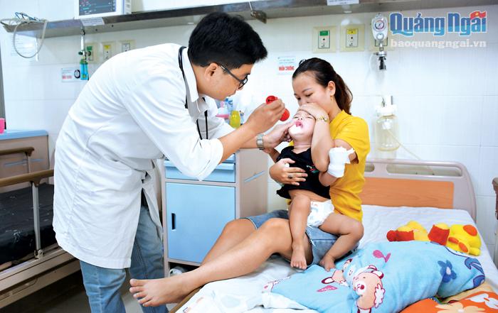 Bác sĩ Phạm Thành Quát, Khoa Bệnh nhiệt đới (Bệnh viện Sản - Nhi tỉnh) kiểm tra trẻ bị bệnh tay chân miệng.