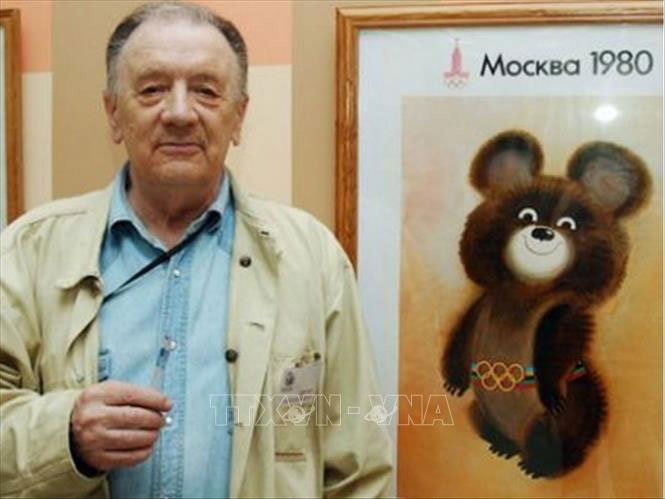 Họa sĩ Viktor Chizhikov chụp ảnh lưu niệm bên cạnh bức tranh gấu Misha - linh vật của Olympic Mátxcơva 1980. Ảnh: The Saxon/TTXVN
