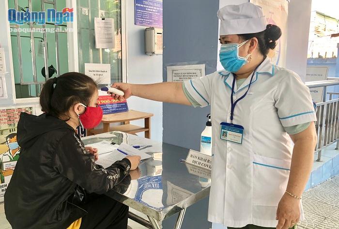 Nhân viên y tế tại Trạm kiểm tra thân nhiệt cho người dân đến khai báo y tế