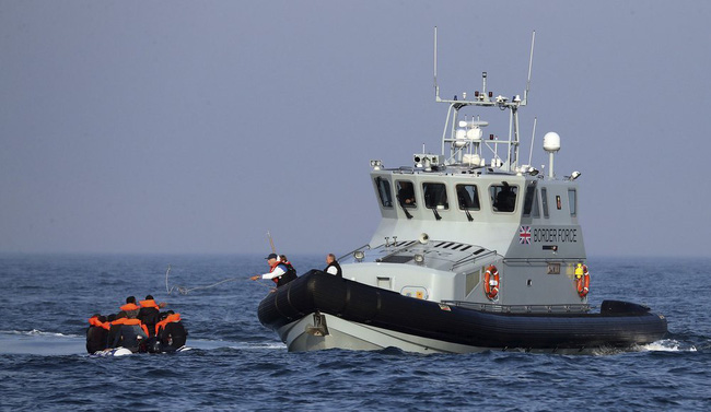 Tàu của lực lượng biên phòng Anh hỗ trợ một nhóm người di cư ở eo biển Manche. (Ảnh: AP)