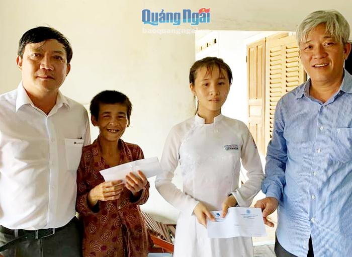 Thầy Bùi Anh Hy (bên trái) trao tiền hỗ trợ cho cô học trò Đặng Thị Kim Anh.