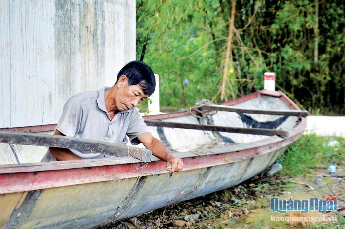 Lão nông Nguyễn Tấn Lê, ở thôn Xuân Hòa, xã Hành Tín Đông (Nghĩa Hành) sửa lại chiếc ghe cũ để dùng trong mùa mưa, lũ sắp đến.