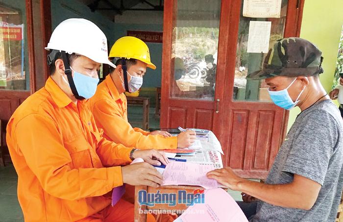 Nhân viên điện lực tuyên truyền và hướng dẫn người dân thôn Nước Giáp, xã Ba Khâm (Ba Tơ) ký cam kết sử dụng điện an toàn.