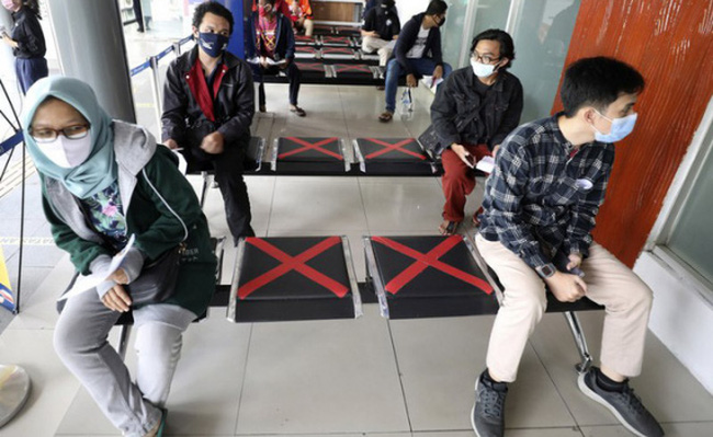 Người dân duy trì giãn cách chờ xét nghiệm COVID-19 bắt buộc ở Jakarta, Indonesia. (Ảnh: AP)