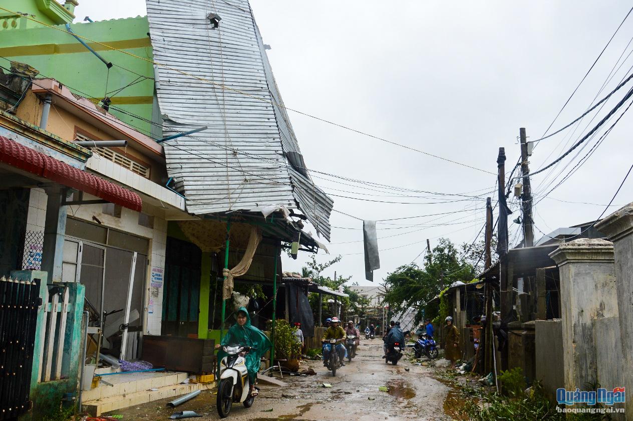 Mái tôn của một gia đình ở xã Bình Hải ngã đổ, treo lơ lửng trên trần nhà, gây nguy hiểm cho người đi đường.