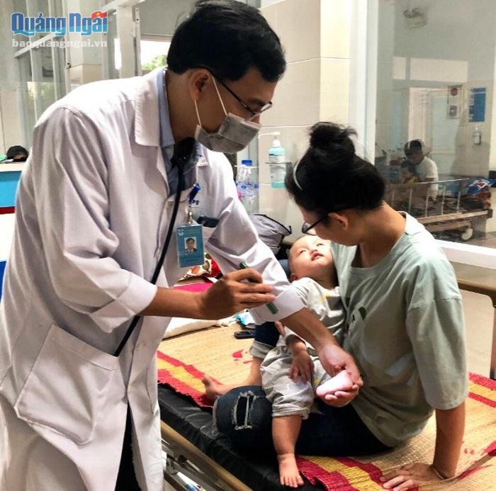 Bác sĩ Nguyễn Mậu Thạch đang khám cho trẻ bị bệnh tay chân miệng.