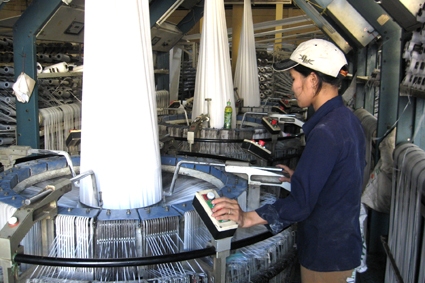   Công nhân làm việc ở dây chuyền dệt thuộc C.ty CP Bao bì Việt Phú.