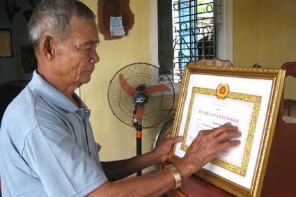 Ông Bầy nâng niu Huy hiệu 60 năm tuổi Đảng vừa được trao tặng.