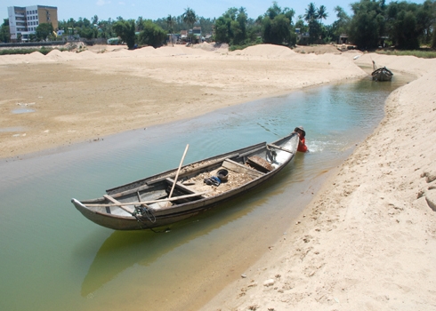  Nước sông Trà mỗi năm một xuống thấp, trơ đáy, những người khai thác cát sạn phải đào một mương nhỏ sâu 4 m để đưa ghe chở hàng vào bờ. Ảnh: Trí Tín.