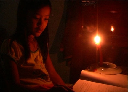   Không có nguồn điện nên em Võ Thị Mỹ Cầm phải học bài dưới ánh đèn dầu.