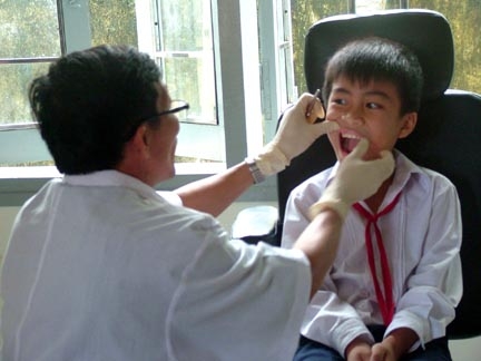 Bác sĩ quân y khám, điều trị răng cho học sinh.