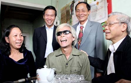 Nhân chuyến về thăm và làm việc tại Quảng Ngãi (trung tuần tháng 1/2012), Tổng Bí thư Nguyễn Phú Trọng (bên phải) đã đến thăm hỏi, động viên thương binh Huỳnh Bình (giữa) ở Hành Thịnh (Nghĩa Hành).  Ảnh: T.toàn