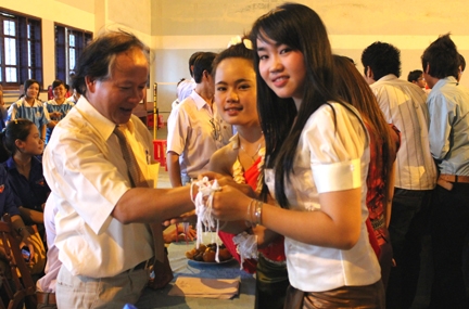 Trong lễ hội Té nước, các sinh viên Lào thực hiện nghi thức buộc chỉ trắng vào cổ tay của các giảng viên với lời chúc may mắn, phúc suốt năm