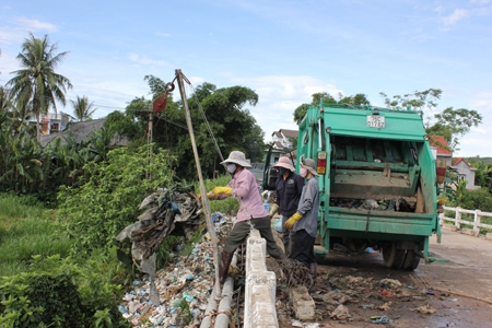 Các công nhân đang chuyển rác thải từ gầm cầu lên xe để mang về điểm tập kết, xử lý rác
