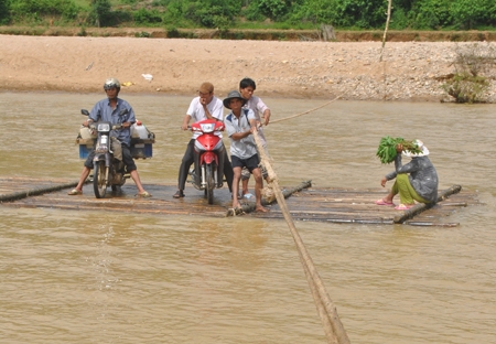 Học sinh và người dân ở một số thôn của xã Sơn Bao (Sơn Hà) đi lại qua sông Tang bằng chiếc bè tre tự tạo, tiềm ẩn nhiều rủi ro.   