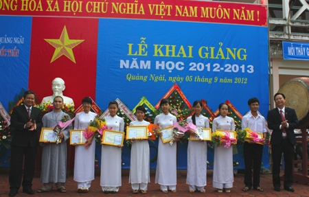Đại diện Sacombank và Ban giám hiệu trường THPT Trần Quốc Tuấn trao học bổng cho 8 em học sinh của trường