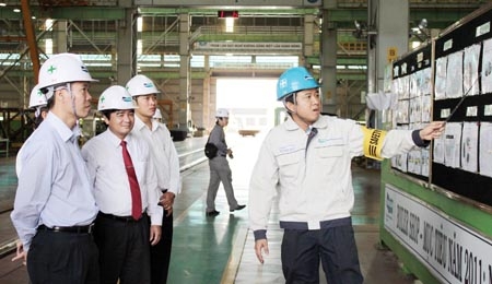 Bí thư Tỉnh ủy Võ Văn Thưởng (bìa trái) nghe báo cáo tình hình sản xuất, xuất khẩu tại Công ty Doosan Vina.