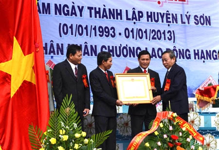 Phó Bí thư Tỉnh ủy Nguyễn Minh (đứng ngoài cùng phía tay phải)trao Huân chương Lao động hạng 3 của Chủ tịch nước cho cán bộ và nhân dân huyện Lý Sơn.